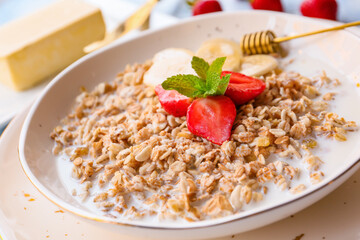 Bowl with tasty sweet oatmeal on table, closeup