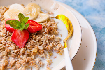Bowl with tasty sweet oatmeal on table, closeup