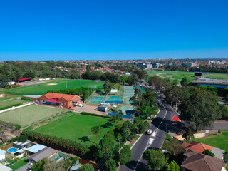 Fototapeta na wymiar Panoramic Aerial Drone view of Suburban Sydney housing, roof tops, the streets and the parks