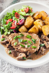 Pork loin chop with mushroom sauce and baked potatoes