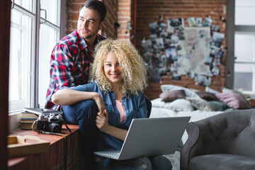 Happy young couple with laptop at home.