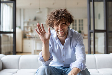 Happy young man blogger influencer waving sit at home speaking looking at camera, webcam view. - obrazy, fototapety, plakaty