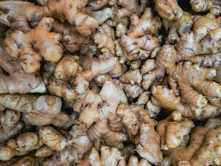 Common ginger (lat.Zīngiber officināle). Raw ginger is in a pile in the supermarket. View from above.