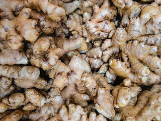 Common ginger (lat.Zīngiber officināle). Raw ginger is in a bunch for sale in the supermarket. Close-up view from the top.