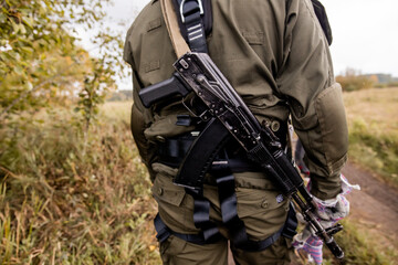 Fototapeta premium Soft focus. Soldier in camouflage holding a finger on the trigger of a Kalashnikov, Special forces team. Russian police (Spetsnaz).