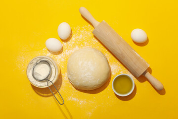 Fototapeta na wymiar Concept for baking with dough on yellow background
