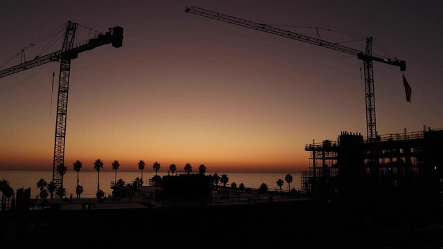 Crane at a construction site during the sunset by the beach.