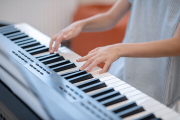 Close up picture of a girl playing on synthesizer