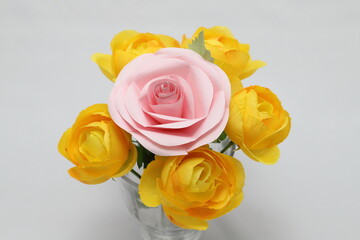 折り紙と布で作ったピンクと黄色のバラの花