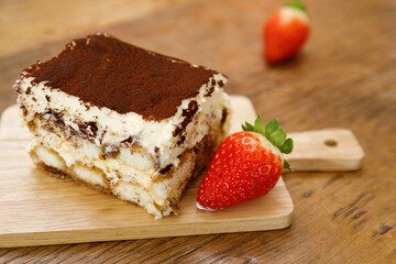 Tiramisu. Traditional italian dessert on wooden plate.