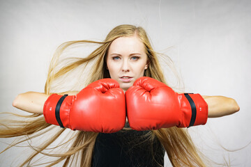 Girl in red gloves playing sports boxing