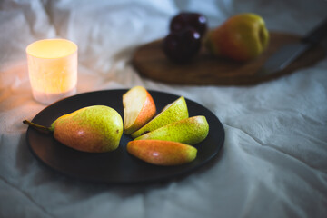 Fruits on black plate with candle light 