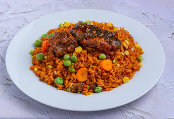 Jollof Rice with stewed goat meat served on a white plate