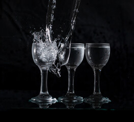 glasses with water with splashes on a black background