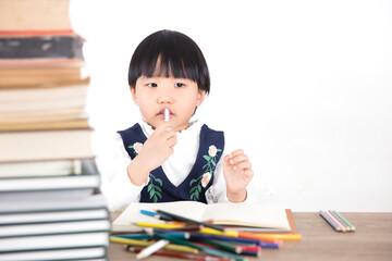 Little girl rubbing her mouth while studying