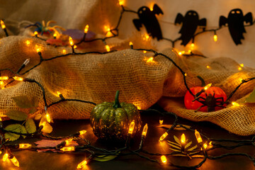 Halloween pumpkins and electric garland in dark. Halloween and autumn concept. Selective focus.