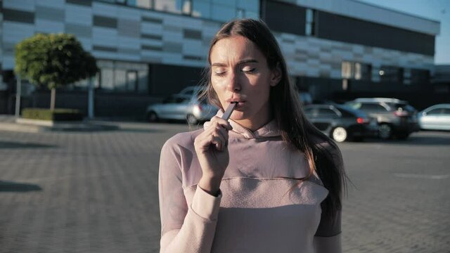 Close up pretty young hipster woman. Happy brunette vaper girl with e-cig. Portrait of smoker female model with electronic cigarette