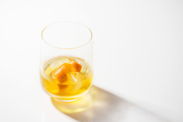 Yellow beverage,cocktale, lemonade  on white background with reflection.Hard light.