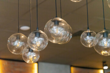 Selective focus of glass hanging lamps on white ceiling. vintage light bulbs.