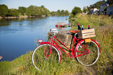 Vieux vélo rouge en bord de la Loire abandonné par un vigneron, caisse de vin dans une caisse en bois.