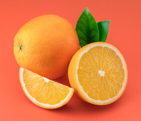 Orange fruit with orange slices and leaves isolated on orange background.