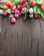Colorful  bouquet of tulips on old wooden background.
