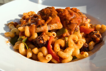 Delicious fresh pasta with grilled chicken breast, vegetables, tomato and parmesan cheese