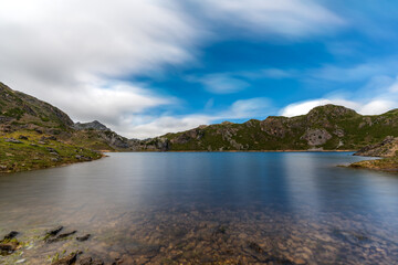 Long exposure of lake, mountains and clouds