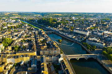Naklejka premium Aerial view of modern cityscape of French town of Laval on banks of Mayenne River in summertime