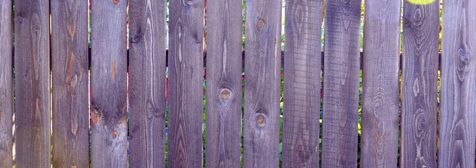 Fence made of planks. Log fence near the site. Wooden background.