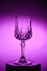 Wineglass on the light background. Fine cristal glassware concept. Vertical, toned in pink