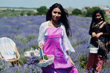 Two beautiful indian girsl wear saree india traditional dress in purple lavender field.