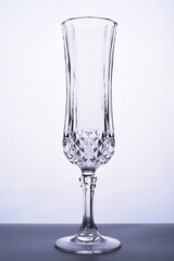 Glass goblet with space for text on a gray background. One wine glass on a gray background. One transparent glass for chompian on a white background
