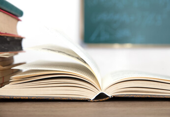 Books opened in front of blackboard