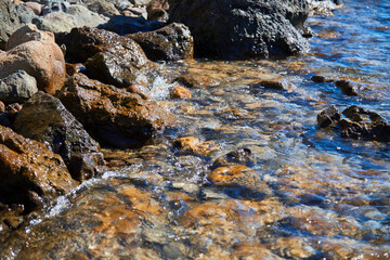 Wet stones and rocky coastline. Summer vibe and holiday. Sunny weather and fresh air. Nature view and tourism concept