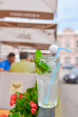 Cold summer fruit and berries lemonade. Mojito lemonade in a glass with a plastic straw outside.