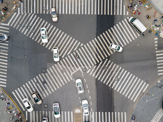 Drone aerial view of cross road with people and traffic cars in downtown. Business concept. Busy traffic in rush hour. Pedestrian walking in the street. Crowded of people urban street Shanghai China