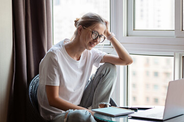 Work from home during coronavirus quarantine. Business Woman using laptop on kitchen. Freelancer talks to colleagues online at video chat. Stay at home during covid-19 concept