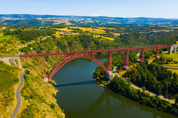 Aerial view of Garabit Viaduct, railway arch bridge spanning Truyere River in summer, Cantal, France