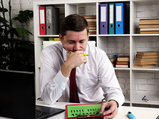Pensive businessman examines bad company business results.