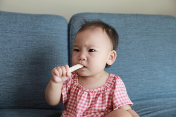 a frowning baby with a cookie bite.
