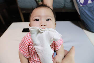 a baby playing with a towel.