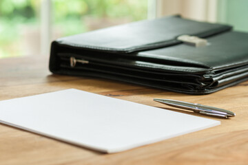 Aktentasche, Papier und Stift auf Schreibtisch