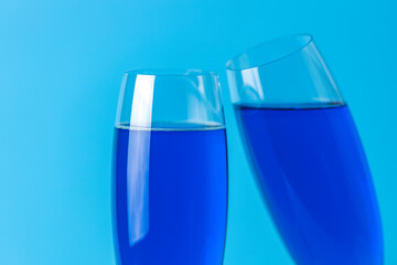 Two wineglasses close up of blue champagne on a blue background. Shallow depth of the field, copy space for you text