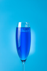 Wineglass close up of blue champagne on a blue background. Shallow depth of the field, copy space for you text