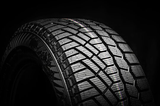 Winter Tire, Friction For Snow And Ice. Asymmetrical Tread Pattern. Close-up On A Black Background