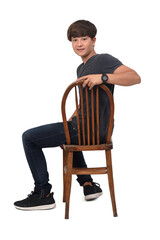 teenage boy sitting on a chair with white background,looking at camera