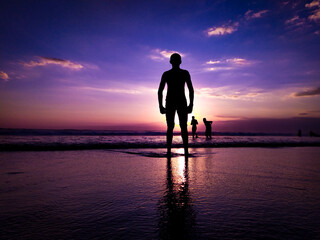 silhouette of a man standing on the beach