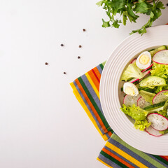 Vegetables salad with cucumbers, quaill eggs and radish. Healthy and diet food concept. Top view. Copy space