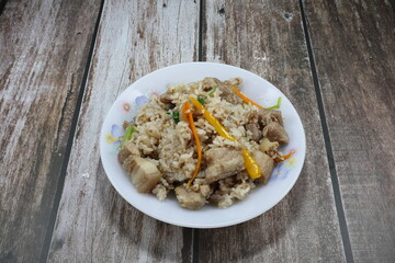 Fried and stirred rice with spicy pork belly, chilly and spring onion seasoning with local sauce in Thai style on the plate. Famous hot and spicy street food menu in Asia. 